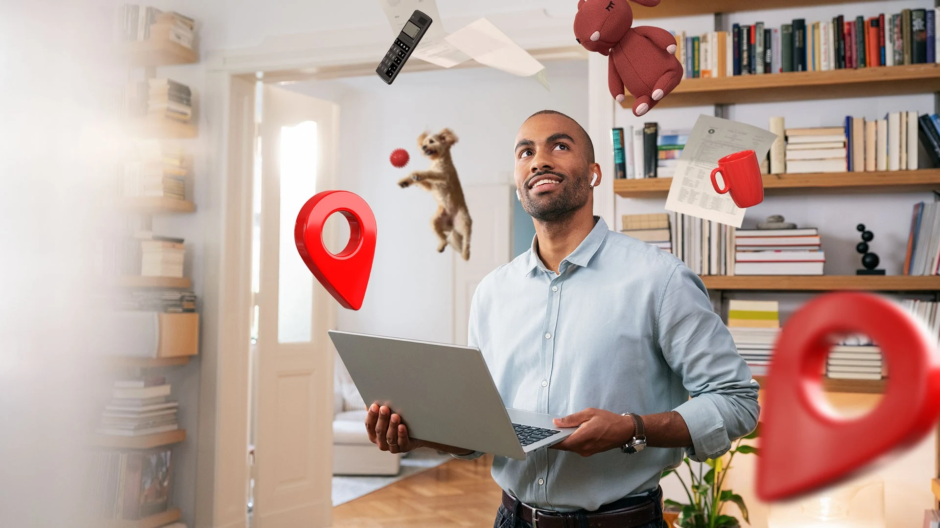 Mann mit Laptop in einem Raum, umgeben von schwebenden Objekten wie Spielzeug, Tasse, Papieren und roten Standortmarkern.